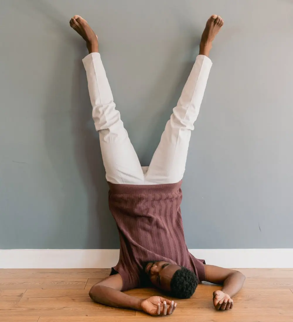 un homme les pieds en l'air dans une pose absurde et humoristique